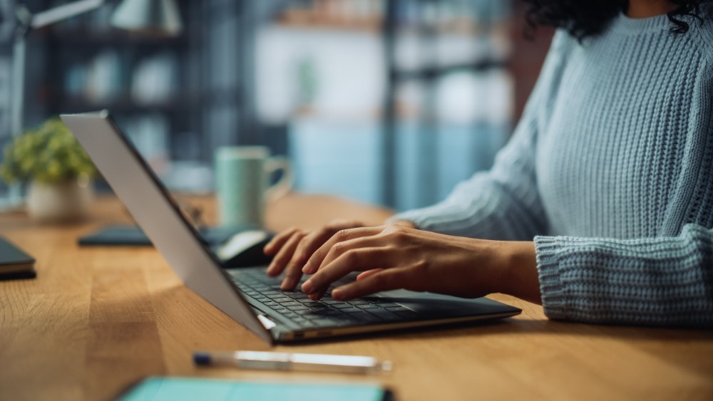 Person's hands typing on a laptop computer